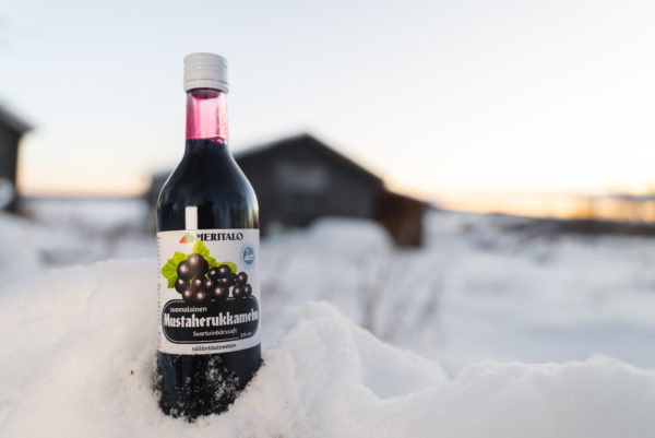 Meritalon suomalainen mustaherukkamehu 375 ml pullo lumihangessa ulkona